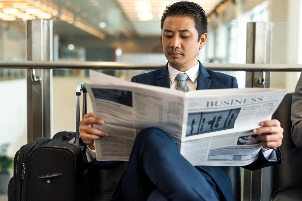 A person reading press releases from a newspaper (illustration)